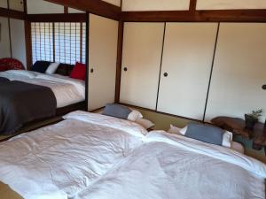 two beds in a room with two bedsructivated at 釜炒り茶の宿陽だまりTraditional Japanese house near Kumano Kodo and Nachi Falls with parking bikes garden and onsite tea house in Nachikatsuura
