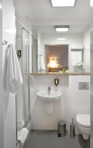 biała łazienka z umywalką i toaletą w obiekcie Hotel Petropol w mieście Płock