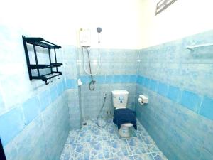 a blue tiled bathroom with a toilet and a shower at Patong Canal Villa 102 in Patong Beach