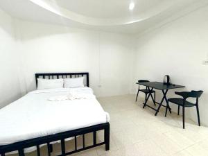 a bedroom with a bed and a table with chairs at Patong Canal Villa 102 in Patong Beach