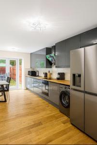 a kitchen with stainless steel appliances and wooden floors at Stylish & Brand-New Home 2025 in Moortown