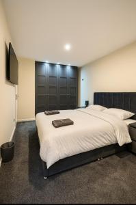 a bedroom with a large bed and a television at Stylish & Brand-New Home 2025 in Moortown