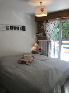 una camera da letto con un letto con un cuscino sopra di Derborence centre 3 pièces 75 m2 piscine balcons a Nendaz