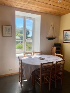 a dining room with a table and chairs and a window at Maison typique du pays bigouden in Tréffiagat +20 photos