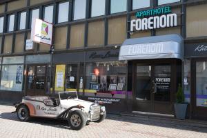 an old car parked in front of a store at LODGE Aparthotel Raahe in Raahe