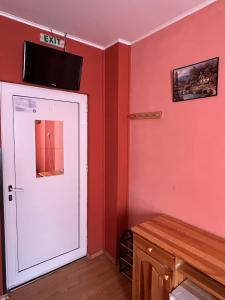 ZărkwischteにあるСемеен хотел Модерния ханの壁にテレビが付いたドアのある部屋