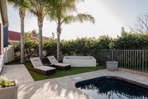 a backyard with a pool and two chairs and a bathtub at Goedehoop Boutique Apartment in Robertson