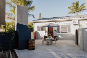 a patio with a table and an umbrella at Goedehoop Boutique Apartment in Robertson