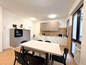 a kitchen with a table and chairs in a room at Maestrale - Elegant Apartment in Udine