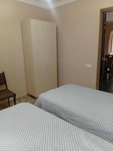 a bedroom with a bed and a cabinet and a chair at Gigi's Guest House in K'obulet'i