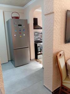 a kitchen with a stainless steel refrigerator with many magnets at Gigi's Guest House in K'obulet'i