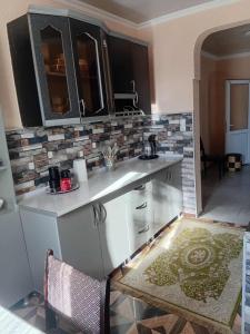 a kitchen with white cabinets and a counter top at Gigi's Guest House in K'obulet'i
