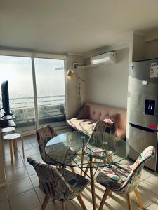 a living room with a glass table and chairs at Central apartment CCP in Concepción