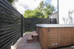 a privacy fence with a bath tub in a backyard at Tranquil Cottage with Hot Tub in Skenfrith