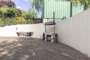 a patio with a table and a cat under an umbrella at Tranquil Cottage with Hot Tub in Skenfrith +38 photos
