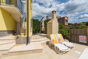 d'une terrasse avec 2 chaises longues sur un balcon. dans l'établissement Villa Sandra, à Kaštelir