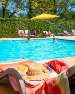 a straw hat sitting on a blanket next to a swimming pool at Glamping Urrugne in Urrugne