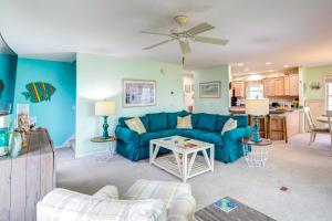 a living room with a blue couch and a table at Bowers Beach Vacation Rental 2 Blocks Away! in Frederica