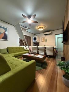 a living room with a green couch and a table at 柳生のおやど in Toyohashi