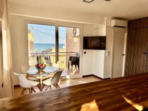 eine Küche mit einem Tisch und Stühlen sowie Meerblick in der Unterkunft The Cozy Coast in Piles