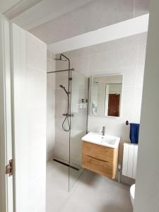 a white bathroom with a sink and a shower at Ocean Breeze in Dunfanaghy