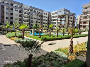 a courtyard with palm trees in front of buildings at Aeroperla Prestige Casablanca Airport in Nouaseur