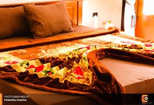 a bed with a blanket on top of it at Sithgiri Drem line cottage in Nuwara Eliya