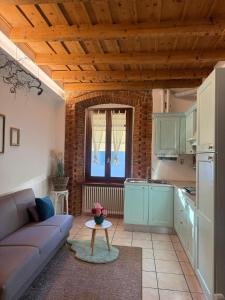 a living room with a couch and a table in a kitchen at Dida's House Aeroporto BGY in Urgnano