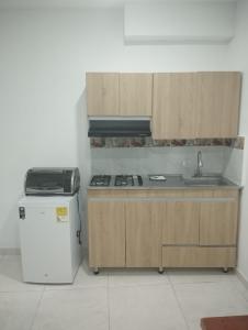 a kitchen with a sink and a stove and a refrigerator at Hospedajes Pilarica in Medellín +42 photos