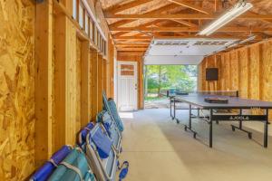 une table de ping-pong dans une pièce aux murs en bois dans l'établissement Glennwood Cottage! Coastal woodsy charm with association beach access, à Fennville