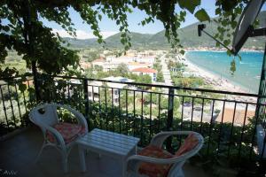a balcony with chairs and a table and a view of the beach at Steven in Vasiliki