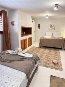 a hotel room with two beds and a tv at Sol do Gostoso Apto in São Miguel do Gostoso