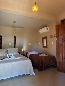 a bedroom with two beds with towels on them at Sol do Gostoso Bangalô in São Miguel do Gostoso