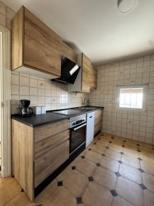 a kitchen with wooden cabinets and a stove top oven at La Granja de Juli in Ledesma