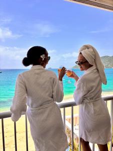 two women standing on a balcony at the beach at Grand Case Beachfront Apartment in Grand Case