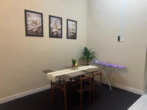 a dining room with a table and some pictures on the wall at KNH Homestay in Kangar +2 photos
