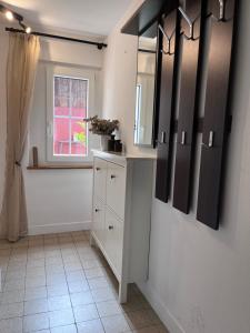 a kitchen with white cabinets and a window at Ferienwohnung am Reichenbach in Hechingen +16 photos