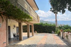 a stone walkway outside of a building with a tree at La Quercia in Borgo Partenope