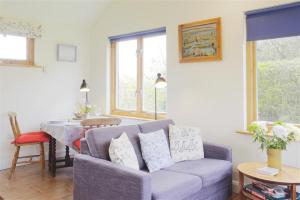 a living room with a purple couch and a table at 1 Bed in Beccles oc-mcn in Henstead +8 photos