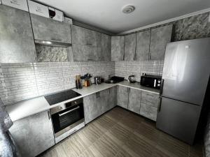 a kitchen with stainless steel appliances and a refrigerator at Шепіт води in Yasinya