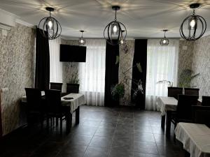 a dining room with tables and chairs and lights at Шепіт води in Yasinya