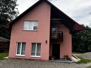 a pink house with a balcony on it at Шепіт води in Yasinya