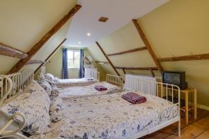 een slaapkamer met 3 bedden op een zolder bij Dressmakers Cottage in Wrentham