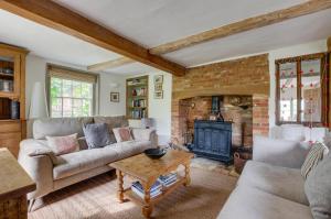 een woonkamer met een bank en een open haard bij Dressmakers Cottage in Wrentham