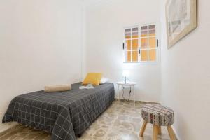a small bedroom with a bed and a chair at Casa Vacacional Bevi - Tenerife Norte in Los Realejos