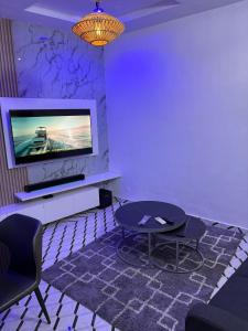 コトヌーにあるLk IMMOのテレビと椅子とテーブルのあるリビングルーム