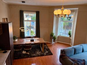 a living room with a table and a blue couch at Charming apartment Nygårdsparken in Bergen +2 photos
