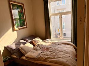 a bed in a room with a window at Charming apartment Nygårdsparken in Bergen