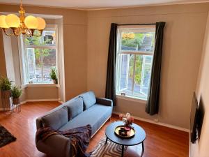 a living room with a blue couch and a table at Charming apartment Nygårdsparken in Bergen