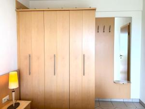 诺德奈Strandvilla Therese Appartment 5的一个带灯的房间的大木柜